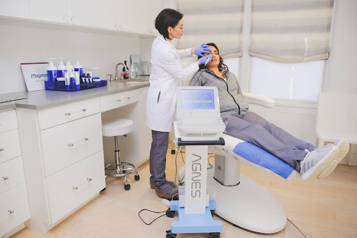 A healthcare professional administers a non-invasive body contouring treatment to a client in a modern clinic setting in Santa Fe.