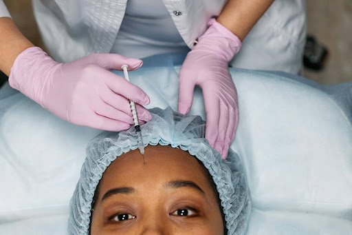 Close-up of a patient receiving a dermal filler injection on the forehead, highlighting the expert care provided for dermal fillers Santa Fe at Seamless Skin MD.